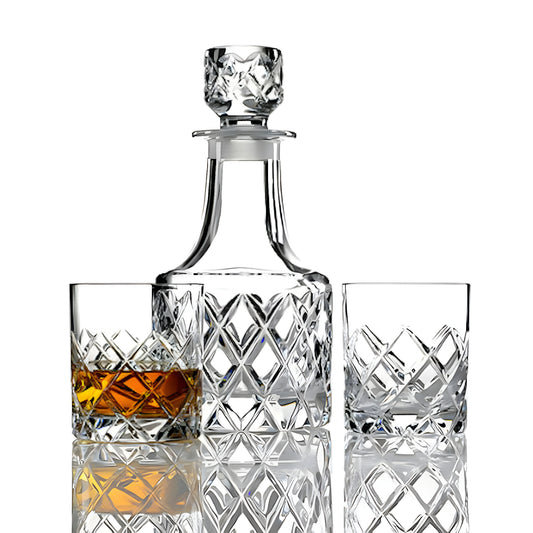 Crystal whiskey decanter set with two tumblers, one filled with whiskey.