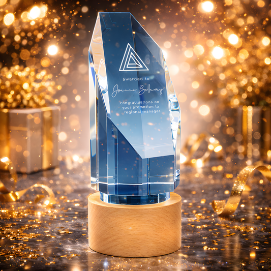 Clear glass award on beechwood base with text congratulating promotion to regional manager.