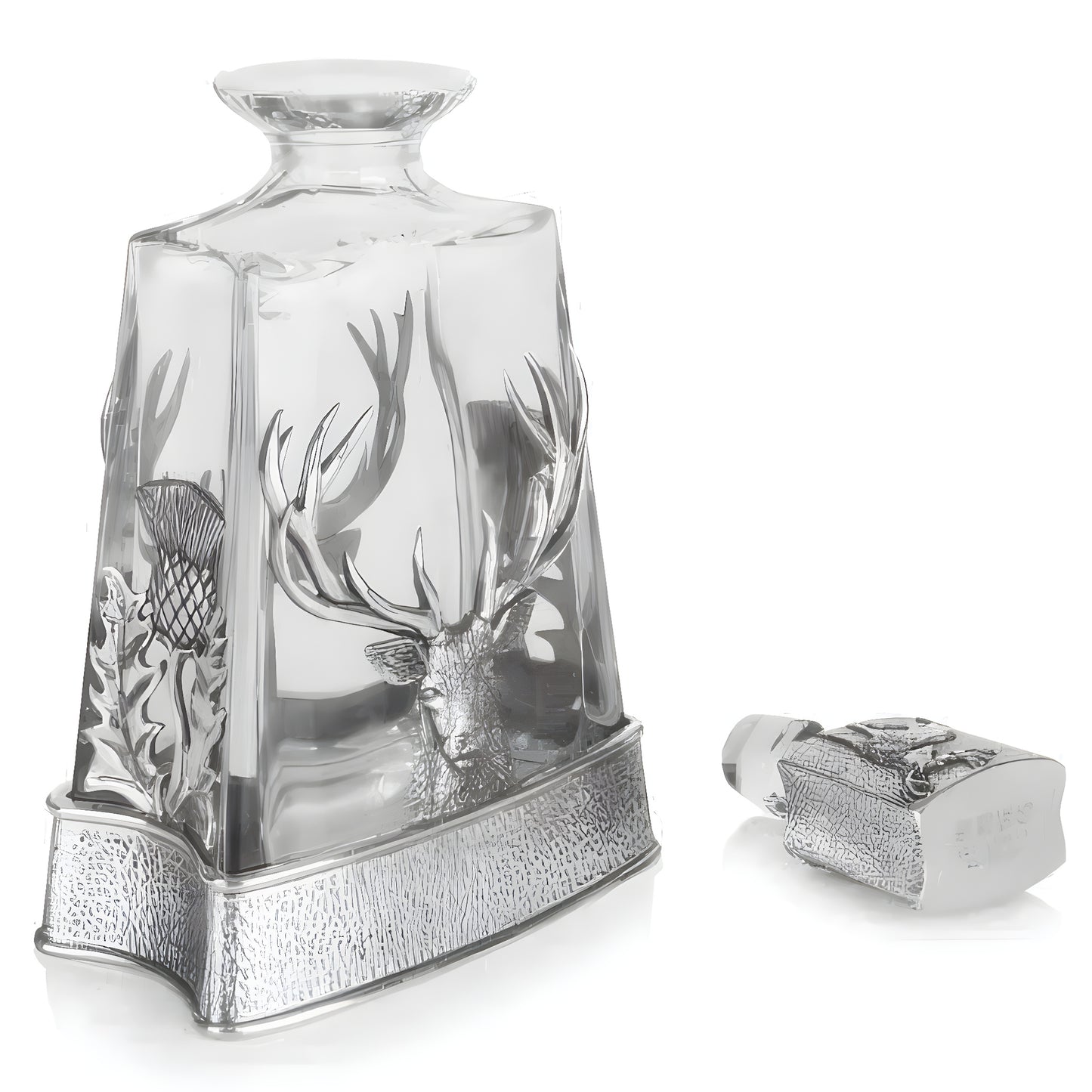 Crystal whisky decanter with stag and thistle design on a reflective surface.
