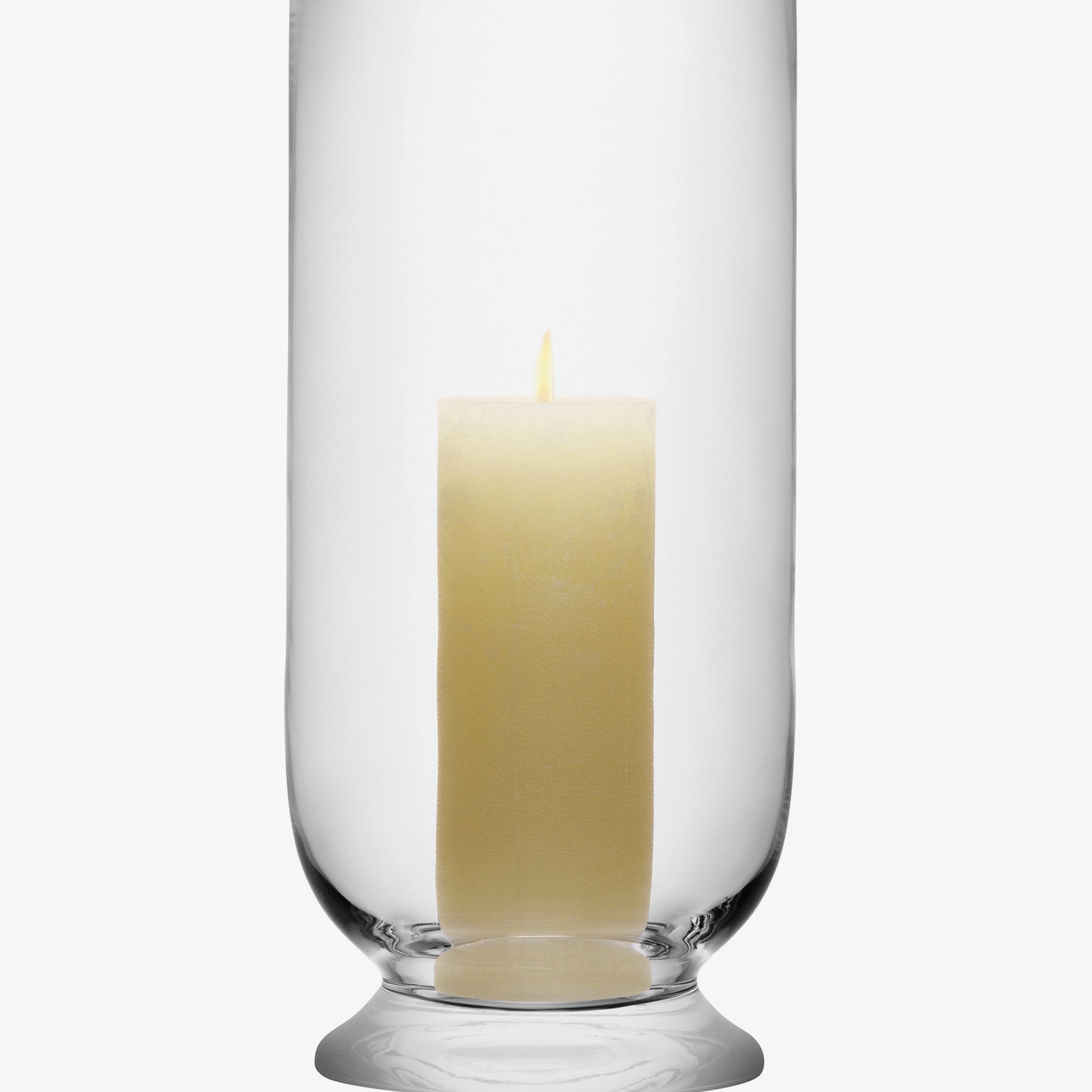 Glass hurricane candle holder with a lit white pillar candle.
