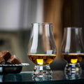 Glencairn whisky tasting glass beside Scotch whisky and chocolates.