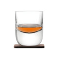 Modern crystal whisky tumbler with wood coaster, partially filled.